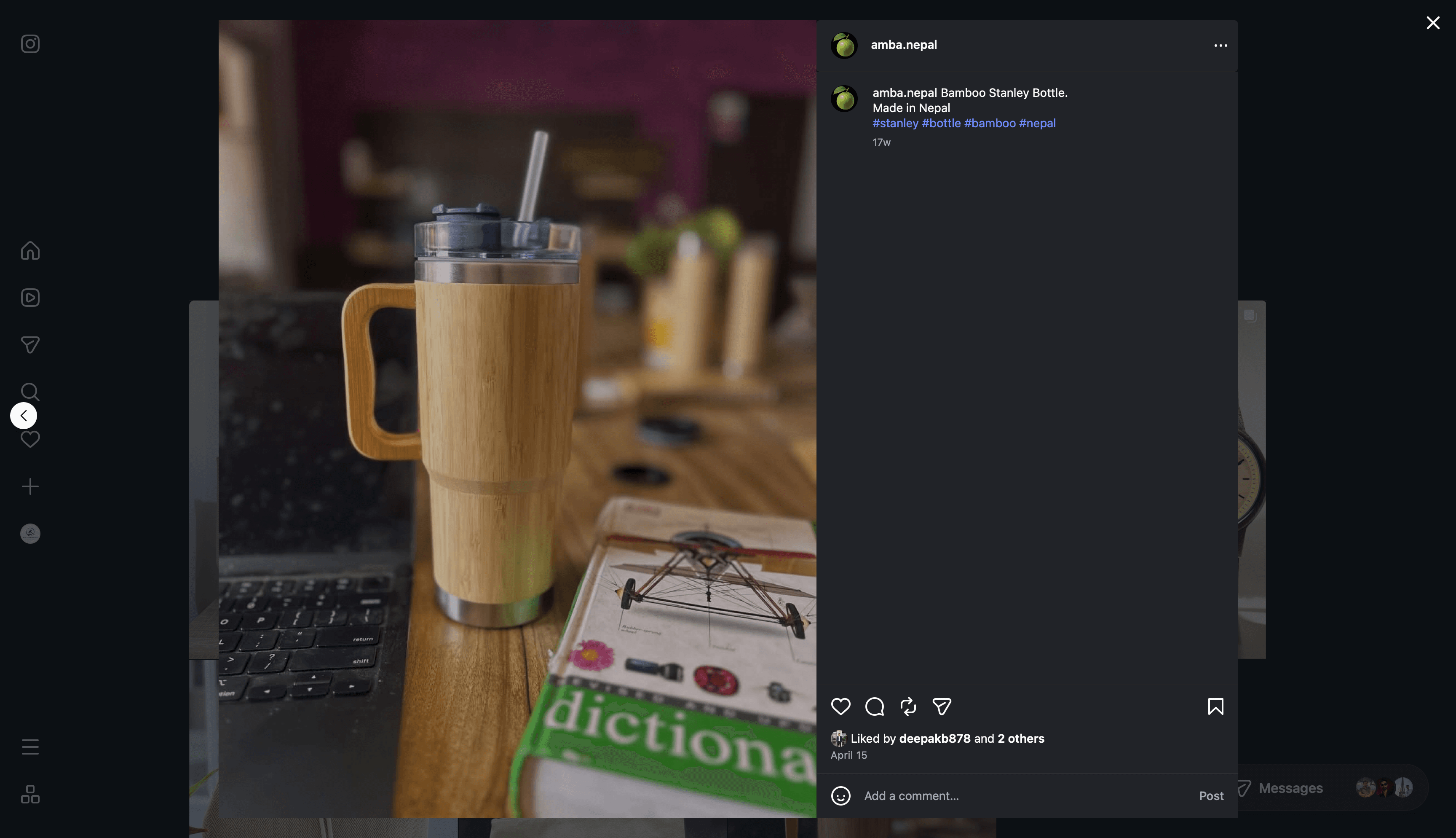 A bamboo travel tumbler with a steel straw, standing on a desk beside an open dictionary