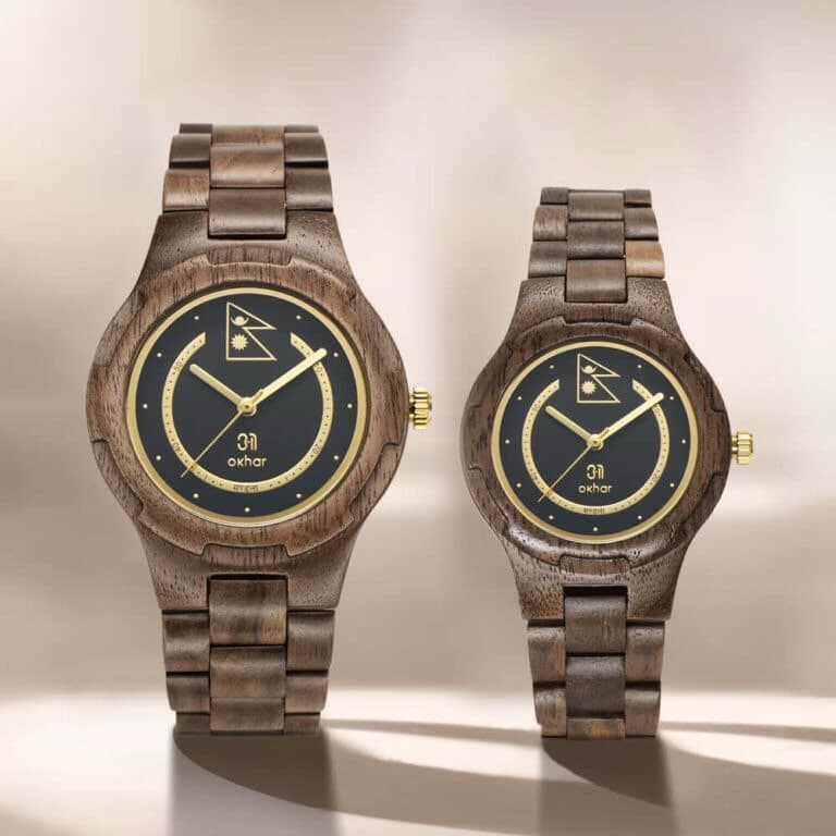 The Okhar watch with the Midnight Emblem dial — two walnut wristwatches with dark faces and gold markers, standing side by side